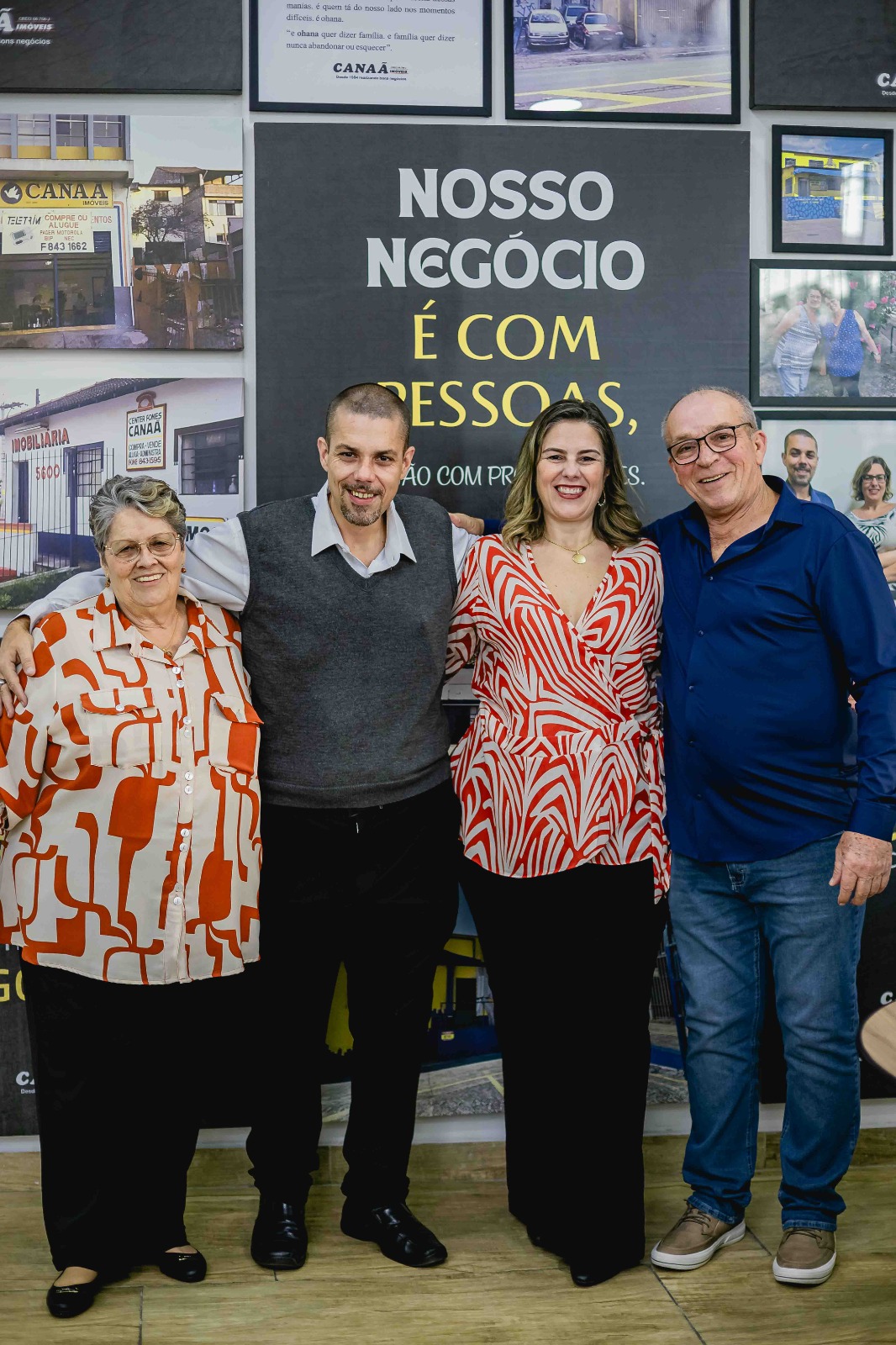 Equipe do Grupo Canaã reunida em frente ao mural institucional